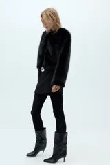 Bota de cuero sintético color negro, con caña media de efecto arrugado, punta fina y tacón fino.