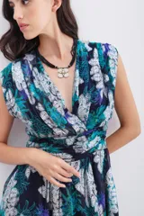 Vestido corto con escote en V cruzado con frunces, sin mangas. Confeccionado en viscosa estampada con jacquard en lurex plateado de motivos florales. Con recorte y ajuste en la cintura. Lleva cierre invisible lateral y forrería a tono.