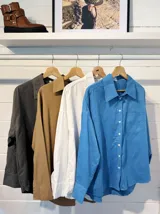 Camisa de gabardina blanca con un corte holgado y mangas largas.