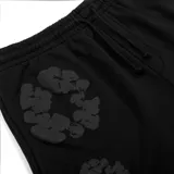 Pantalón de jogging negro con estampado de flores grises, corte holgado y cintura con cordón ajustable.
