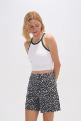 Top blanco de poliamida, corte cropped, al cuerpo y cuello a la base con ribete verde.