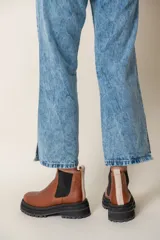 Borcegos negros de cuero vacuno con elástico lateral, suela track y tirador trasero.