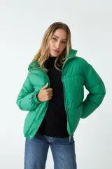 Campera puffer lila de nylon con cuello alto, cierre frontal con cremallera y bolsillos laterales con cierre.