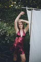 Vestido corto con lentejuelas color verde esmeralda, escote en V profundo y espalda descubierta.