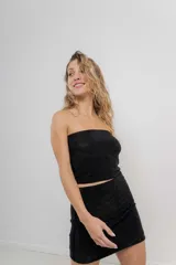 Minifalda negra ajustada al cuerpo, de tejido elástico con strass incorporado y tiro alto.