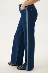 Pantalón de jean azul con corte acampanado y diseño de bloques de color en diferentes tonos de azul.