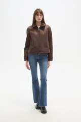 Campera marrón de poliéster con cuello y puños de corderito, cierre frontal y bolsillos laterales.