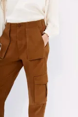 Pantalón tipo cargo color ocre, de calce relajado, con elástico en la cintura trasera y bolsillos laterales con solapa.