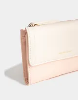 Billetera color rosa pálido con estampado de flores pequeñas, formato fichero con solapa y tag en relieve. Tiene cierre superior con puller, solapa con broche, compartimento para tarjetas y bolsillo interno con solapa.