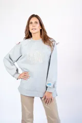 Sudadera gris melange de corte oversize con logo de la marca bordado en el frente y bandera de Uruguay bordada en la manga.