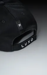 Gorra de béisbol negra lisa con visera curva y botón superior.