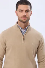 Buzo tejido de algodón color azul marino, con cuello alto y cierre frontal parcial con detalle de cuero en el tirador.