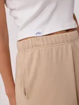 Short color beige de tiro alto con cintura elástica y bordado en el frente.