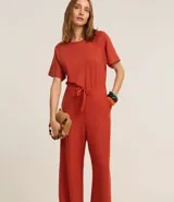 Mono largo color ladrillo, de corte recto, con cuello redondo y mangas cortas. Cuenta con cintura elástica, cordón en la cintura y abertura en forma de V en la espalda.