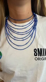 Collar de múltiples hilos de cuentas azules de diferentes tamaños.