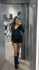 Minivestido negro de lycra con espalda descubierta y detalle de hebilla metálica dorada en la parte superior de la espalda.