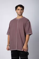 Remera negra oversize con mangas cortas y costuras a la vista en color blanco.