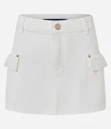 Minifalda cargo color blanco, confeccionada en sarga de algodón, con trabillas, bolsillos laterales y cierre frontal con botón.