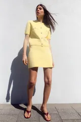 Minifalda amarilla de punto liso, tiro alto, cintura elástica y corte evasé.