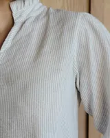 Blusa celeste con cuello mao y mangas abullonadas.