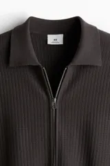 Cárdigan marrón de punto acanalado con cuello polo y cierre de cremallera.