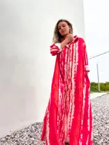 Vestido camisero largo con estampado batik en tonos rojo y beige, con cuello camisero y mangas largas con puños.