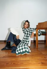 Bufanda tejida a máquina con diseño de rombos en tonos marrón, azul, verde y amarillo. Terminación con volados.