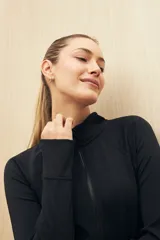 Campera deportiva negra con cierre frontal y cuello alto.