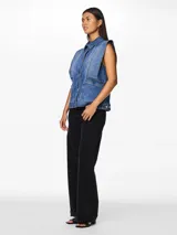 Chaleco denim azul de corte holgado con cierre de botones. Tejido suave con estructura ligera.