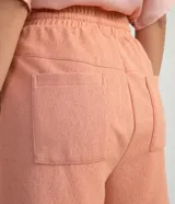 Short de poliéster color salmón con cintura elástica, cordón de ajuste, bolsillos laterales y pliegues frontales.