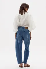 Camisa blanca de lino con estampado de cuadros azules y marrones, cuello camisero clásico, mangas largas abullonadas con puños elásticos, botones de nácar frontales y ruedo curvo.