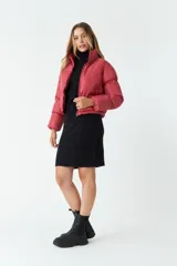 Campera puffer corta color ladrillo, con cuello alto y cierre frontal.