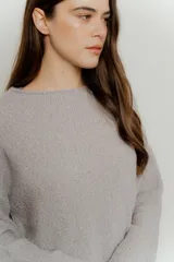 Sweater de punto color gris claro, de corte holgado y mangas largas.