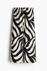Pantalón tobillero de viscosa con estampado abstracto en blanco y negro, tiro alto con elástico en la cintura, bolsillos laterales y piernas amplias rectas.