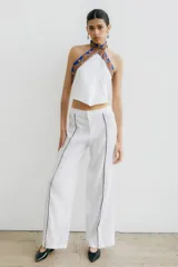 Pantalón recto color crema de lino con costuras laterales en negro.