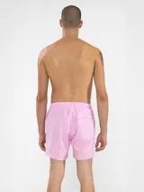 Short de baño rosado con estampado de lunares blancos, cintura elástica con cordón ajustable, bolsillos laterales y trasero con cierre, y suspensor de malla fina hipoalergénica.