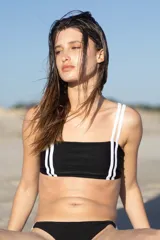 Top de bikini negro con escote recto, tirantes dobles blancos y banda inferior con ribete blanco.