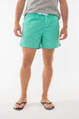 Short de baño azul con estampado de hojas de palmera en tonos azules, blancos y rosados.