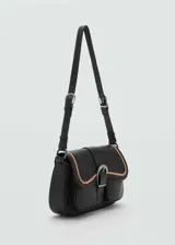 Bolso bandolera negro de cuero con asa ajustable, cierre de hebilla y detalle en contraste color beige.