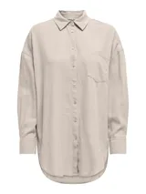 Camisa oversize color beige, con cuello clásico, mangas largas con puños abotonados, cierre frontal con botones y bolsillo de parche en el pecho.