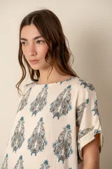 Camisa de lino color crudo con estampado de cachemir en tonos azules y marrones, de corte holgado, manga corta con dobladillo y cuello redondo.
