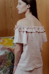 Blusa rosa de lino con escote off shoulder y volados.