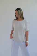 Blusa beige de lino con cuello redondo, mangas cortas con dobladillo y botones decorativos en el lateral.