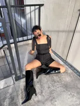 Top negro con estampado a rayas verticales blancas, breteles anchos con lazos en los hombros y corte ajustado.