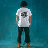 Remera blanca de corte recto con cuello redondo y manga corta. Estampado pequeño en el pecho de una calavera con un sombrero.