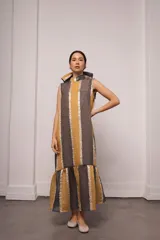 Vestido largo y amplio con cuello alto y mangas cortas abullonadas. Diseño a rayas verticales en tonos dorado y gris. Incluye viso liso al tono.
