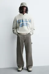 Zapatillas deportivas color crema con cordones, suela gruesa con diseño irregular y detalles en gris.