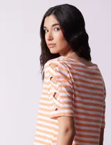 Remera de algodón a rayas horizontales color naranja y blanco, de manga corta y cuello redondo.