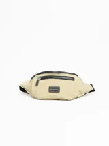 Riñonera color beige con cierre superior negro y logo de la marca en el frente.