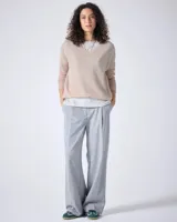 Sweater de cashmere color lila con cuello en V, corte oversize, mangas largas, hombros caídos y terminaciones acanaladas.